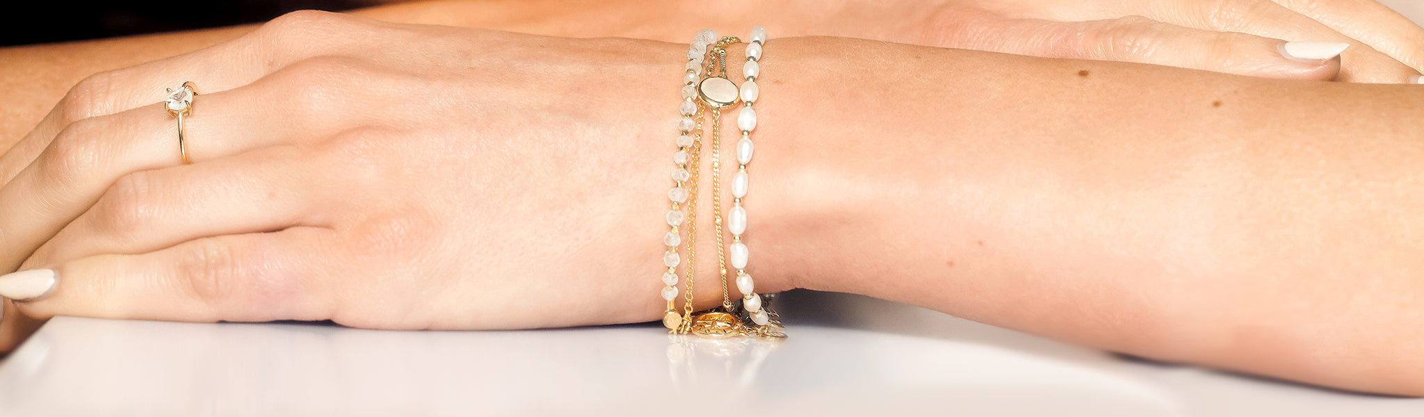 Model wearing elegant gold and gemstone bracelets showcasing Christin Ranger's modern luxury design in gold vermeil bracelets