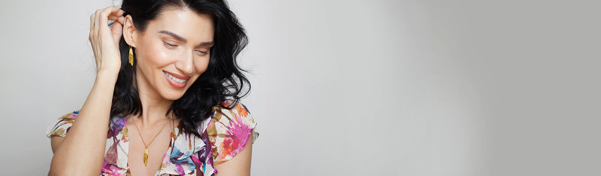 Model showcasing bold, dangly gold earrings from Christin Ranger's Statement Earring Collection in silver and gold