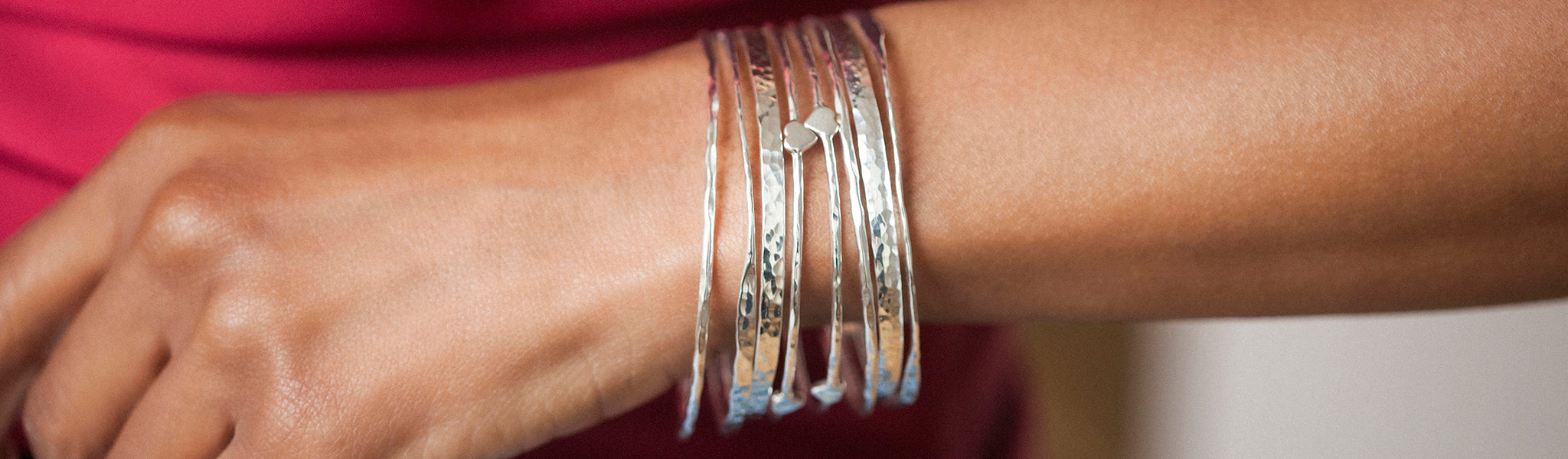 A wrist wearing plain silver bangles displayed elegantly, showcasing minimalist design and handcrafted finish.