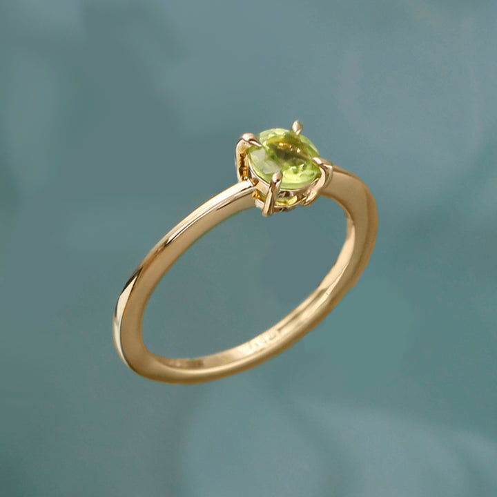 Peridot ring in 18ct gold vermeil on an aqua background