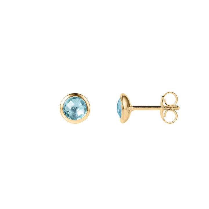 Pair of dainty gold stud earrings with blue gemstones on a white background