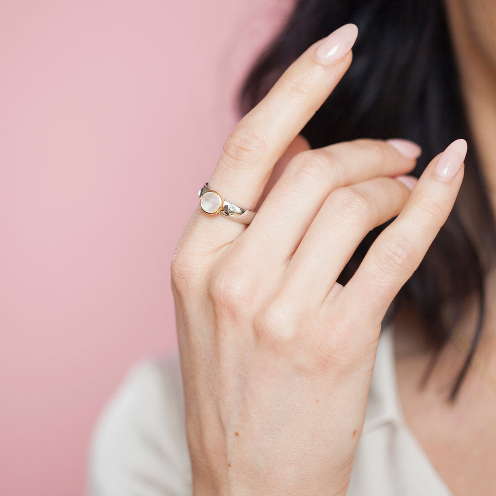 Close-up of woman wearing a natural white moonstone ring in sterling silver with 18ct gold vermeil setting