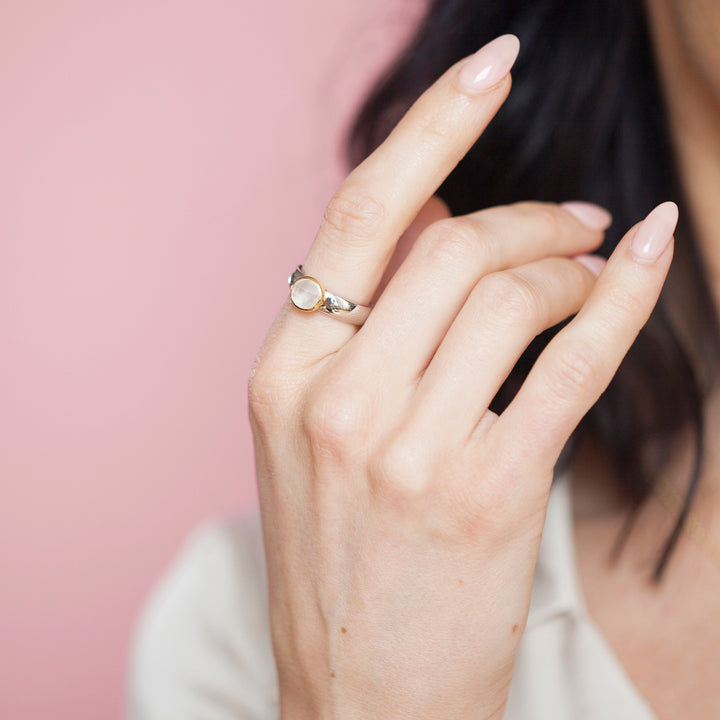 Close-up of woman wearing a natural white moonstone ring in sterling silver with 18ct gold vermeil setting