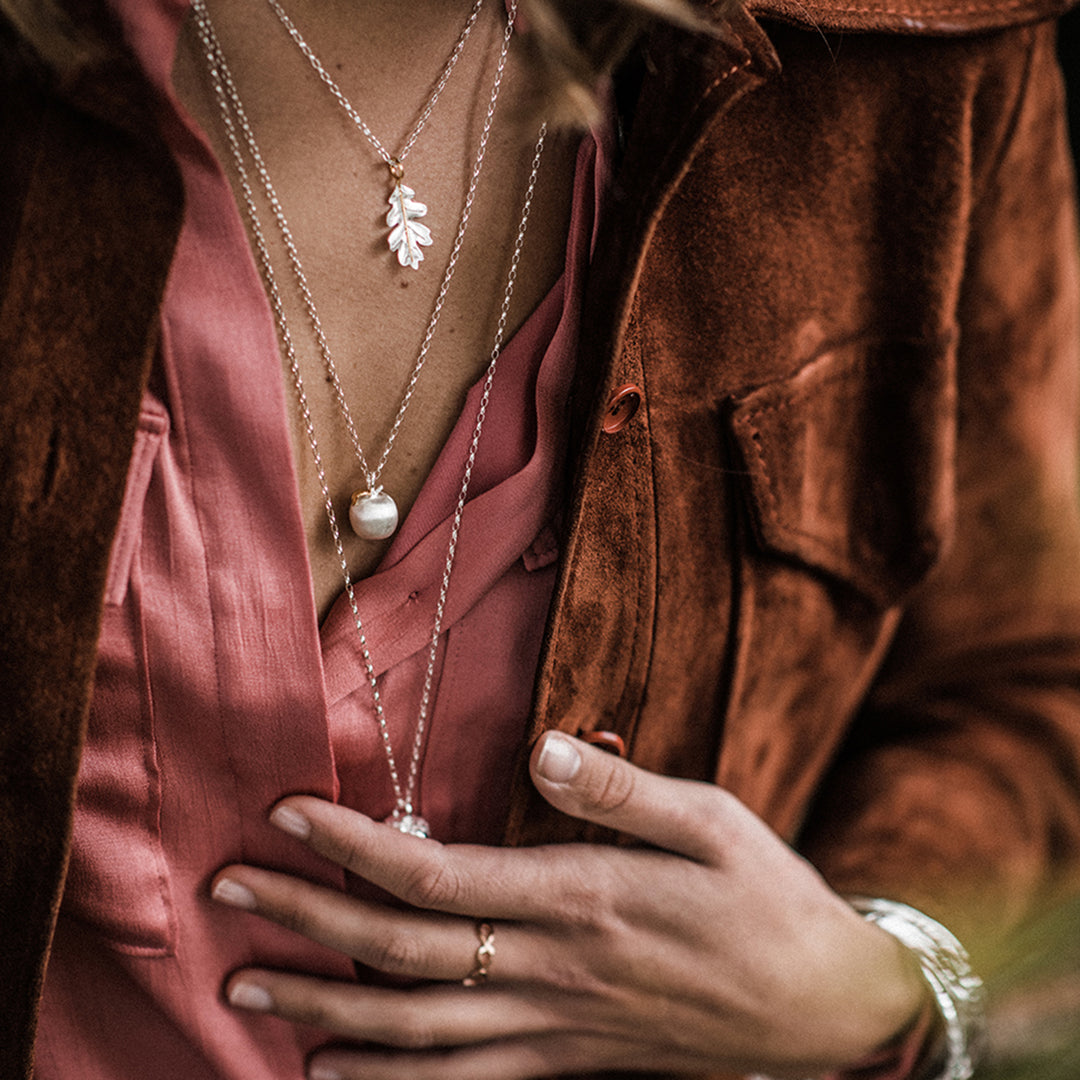 Close-up of a model wearing silver layering necklaces
