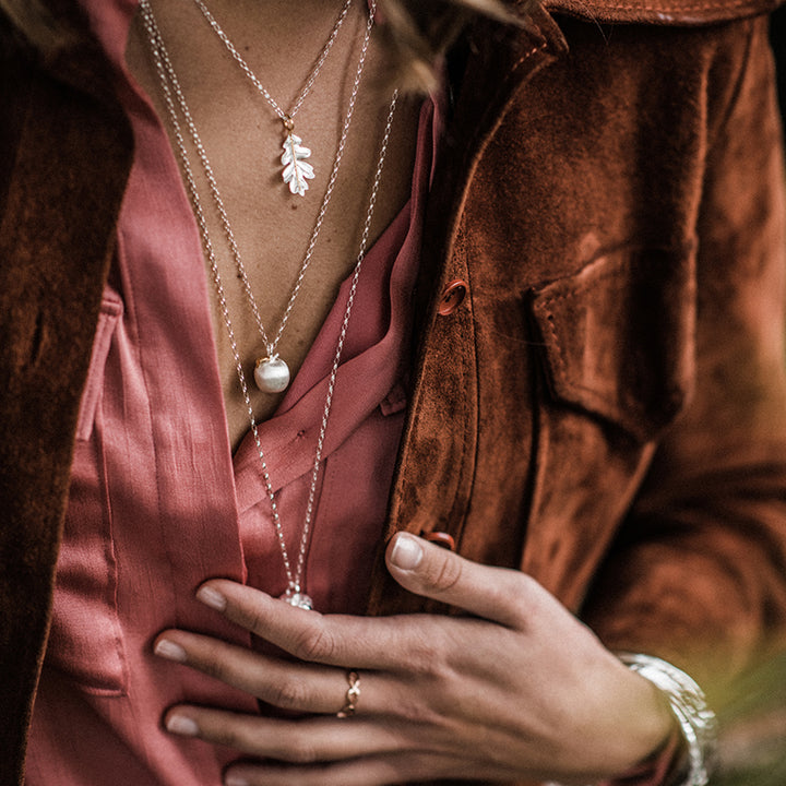 Close-up of a model wearing silver layering necklaces