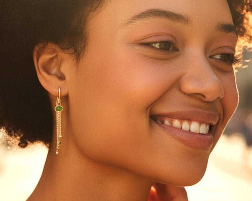 Woman wearing peridot chandelier earrings in gold vermeil with garnet drops
