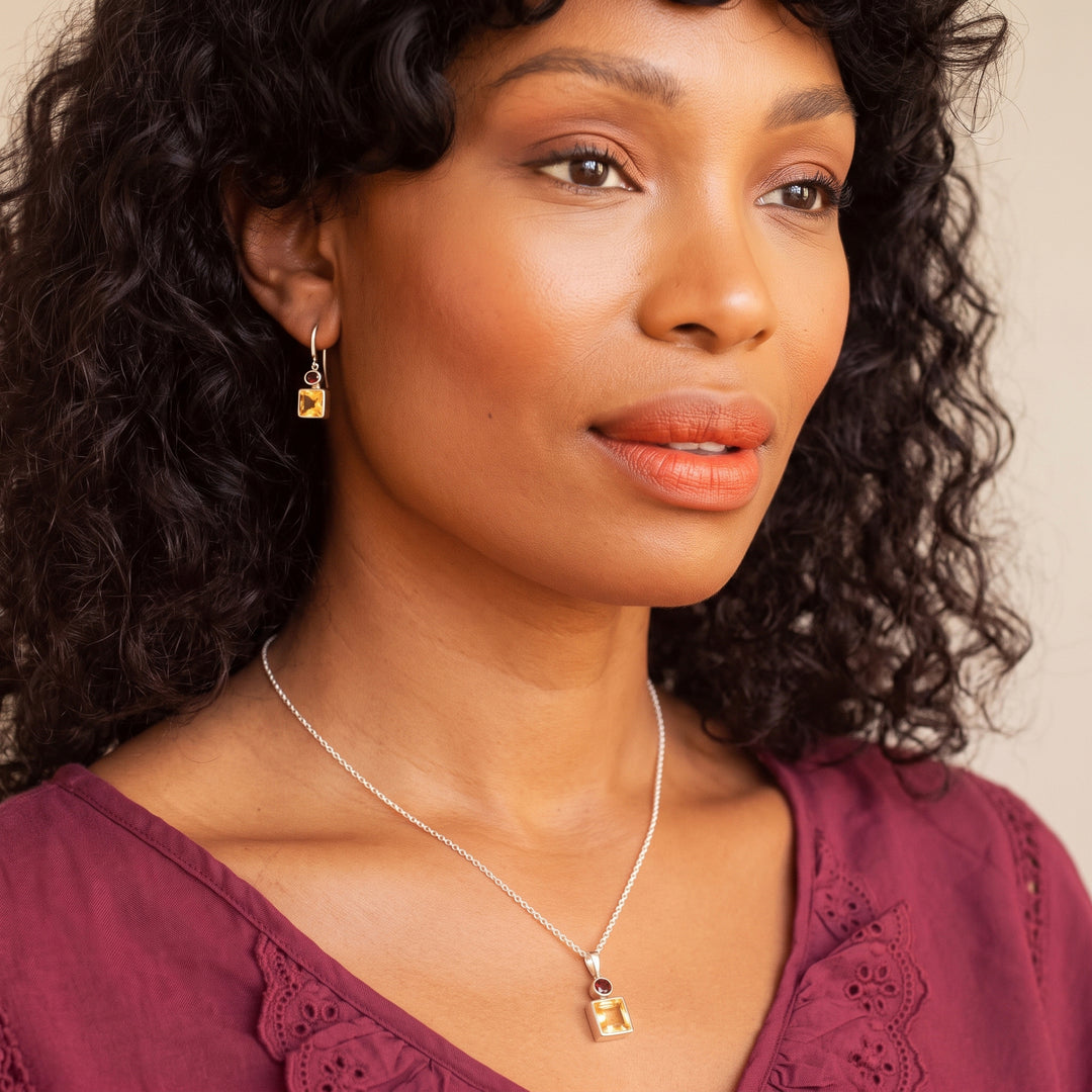 Woman wearing square citrine & oval garnet drop earring and matching necklace set in sterling silver
