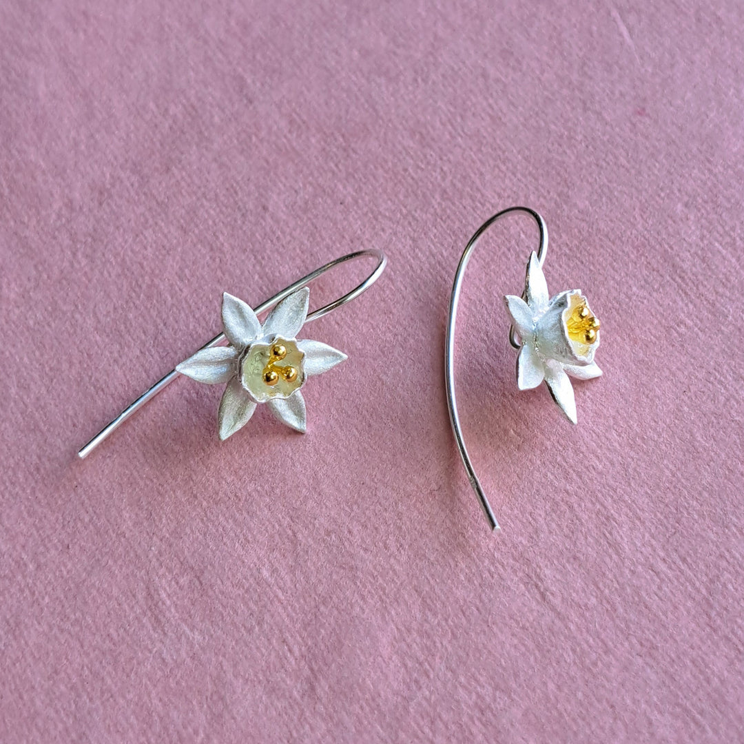 Sterling silver daffodil flower drop earrings on pink background – alternative view