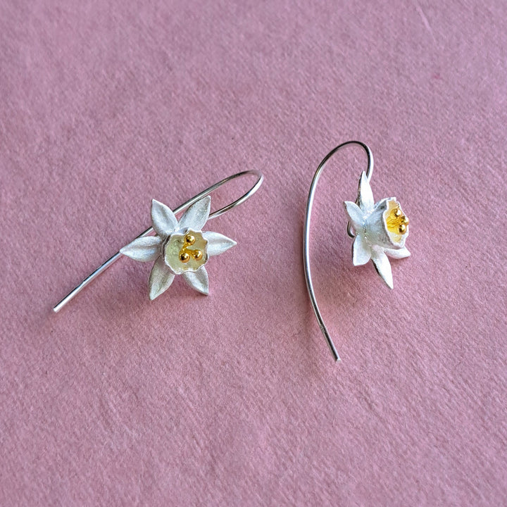 Sterling silver daffodil flower drop earrings on pink background – alternative view