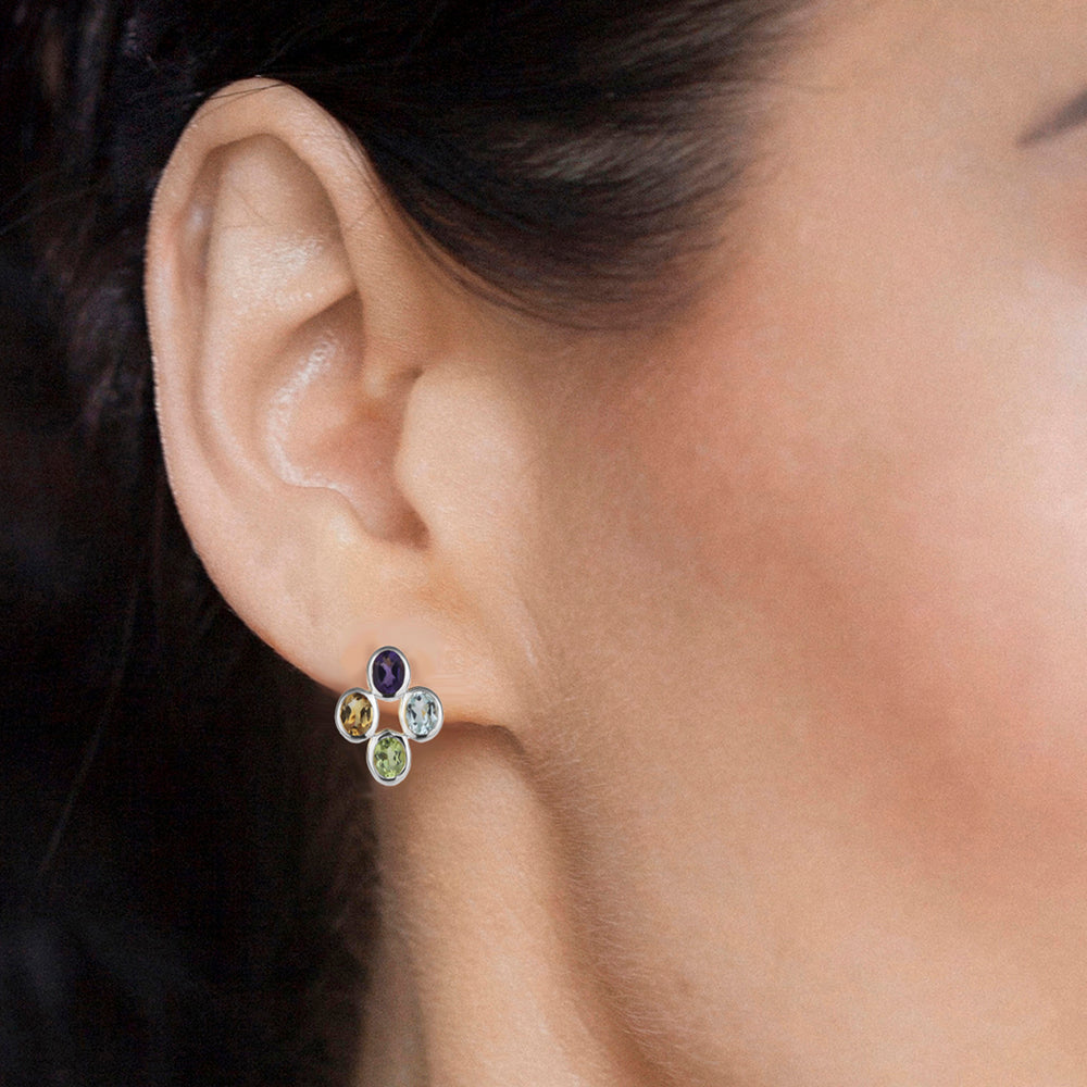 Close-up of an ear wearing a silver square multi-colored gemstone earring.