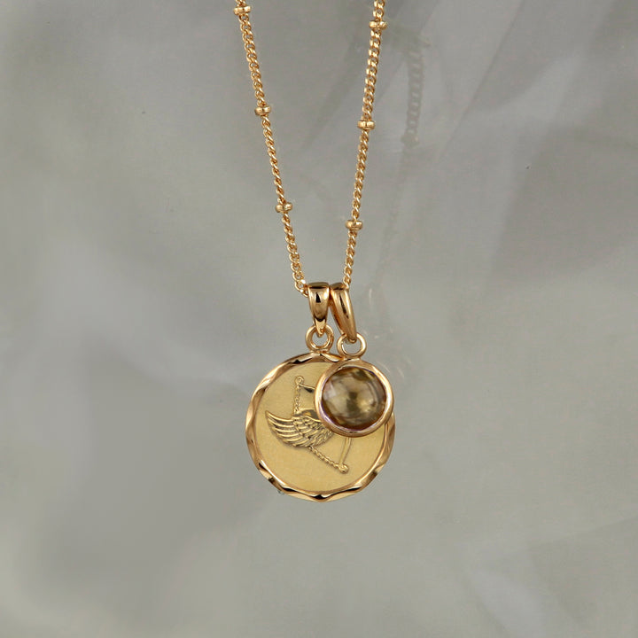 Gold zodiac pendant  with Sagittarius  star sign and smoky quartz November birthstone charm on gray background