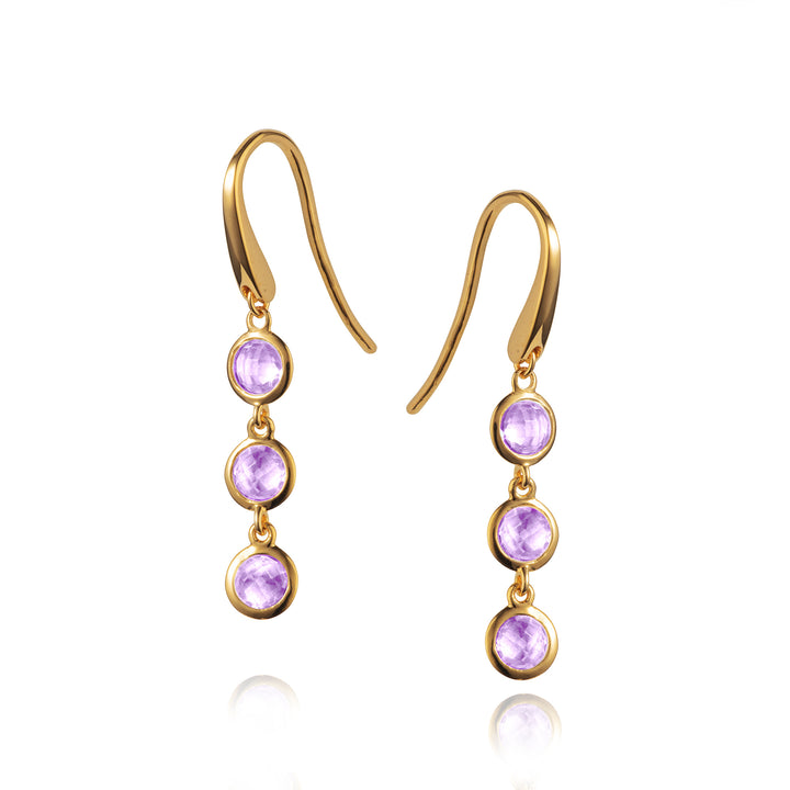 gold triple stone earrings set with purple amethyst on a white background