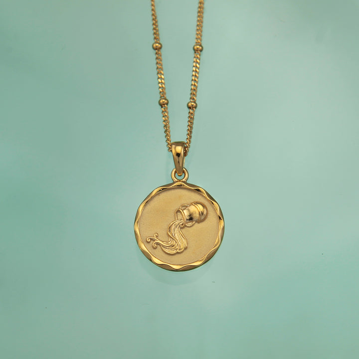 18ct gold vermeil Aquarius zodiac star sign pendant necklace on a teal background