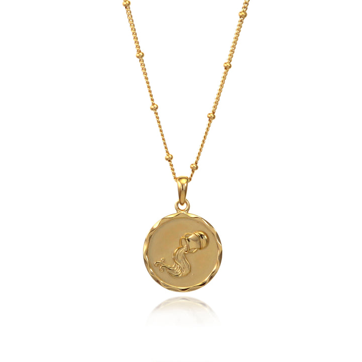 Gold Aquarius zodiac pendant and beaded chain against a white background