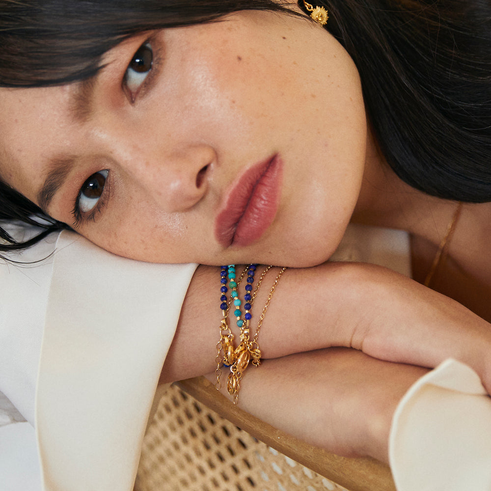 Woman wearing a gold vermeil beaded compass bracelet in lapis lazuli