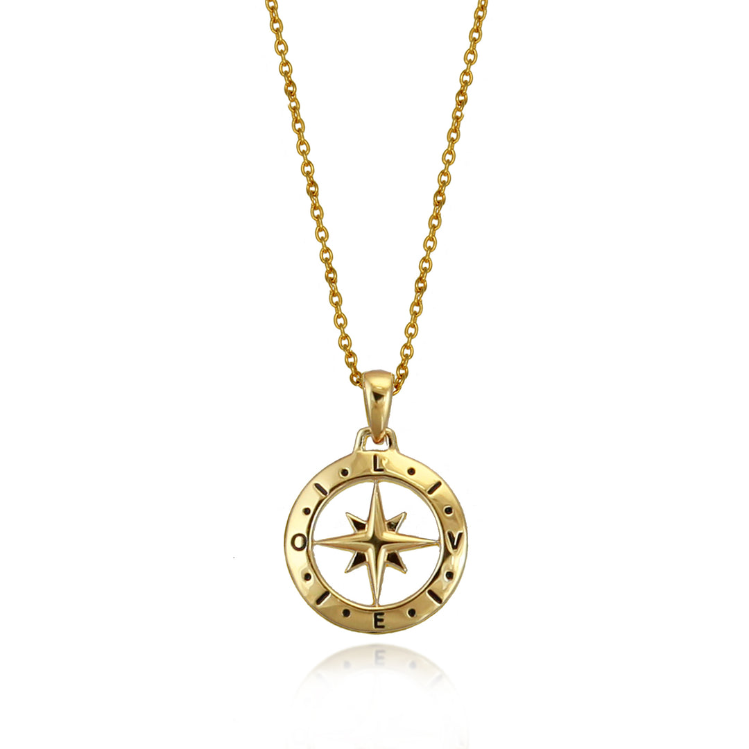 Gold compass pendant with the words love spelled out against a white background