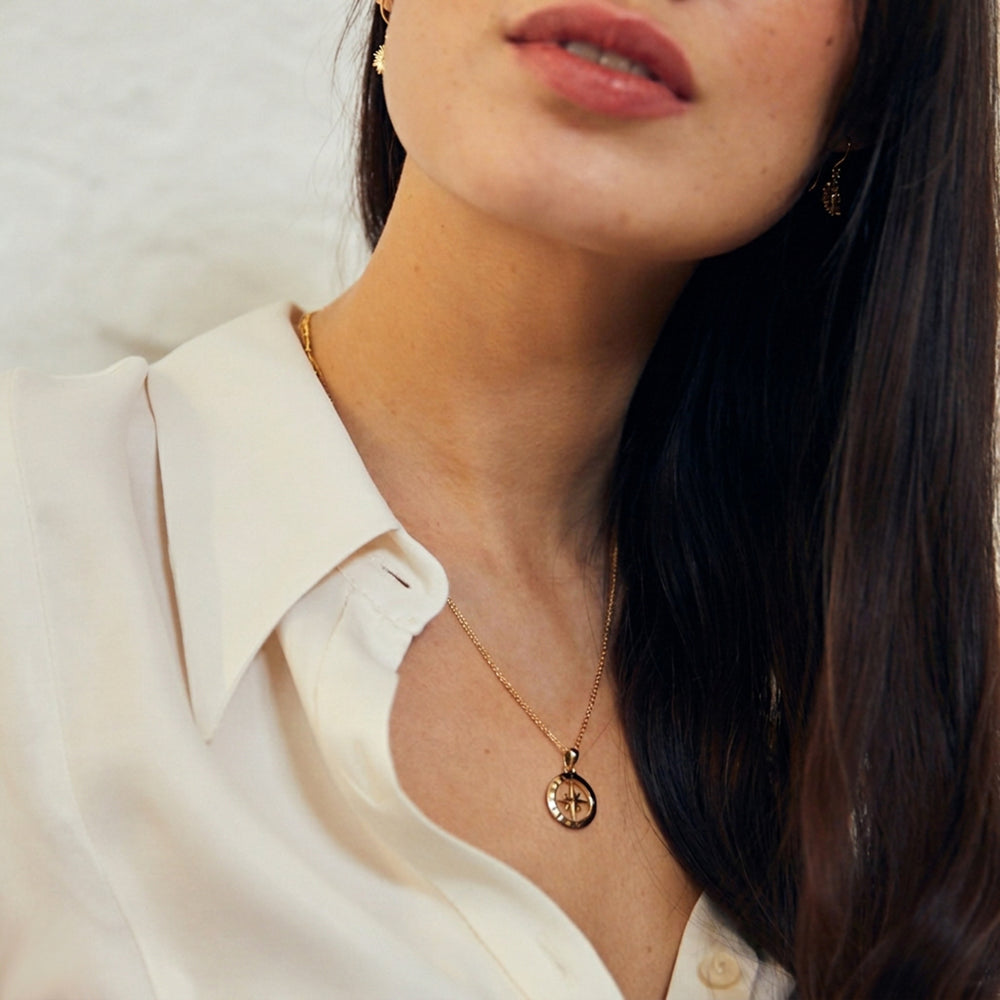 Woman wearing a gold vermeil compass pendant necklace
