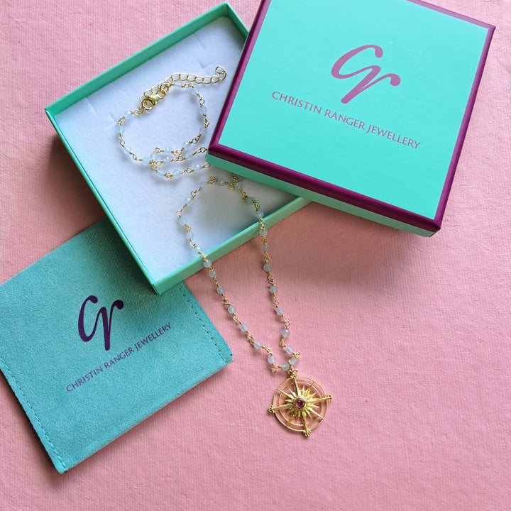Gold tourmaline and blue chalcedony sun necklace in a Christin Ranger jewellery box.