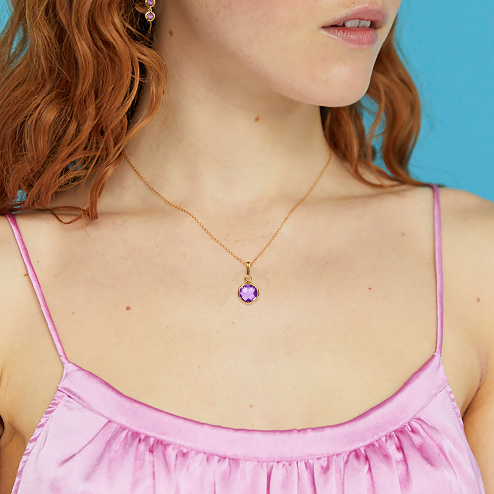 Close-up  of model wearing dainty gold and amethyst pendant necklace