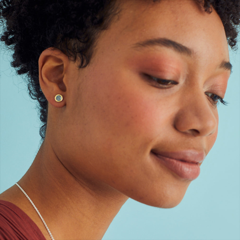 Model wearing gold vermeil and blue gemstone post earrings