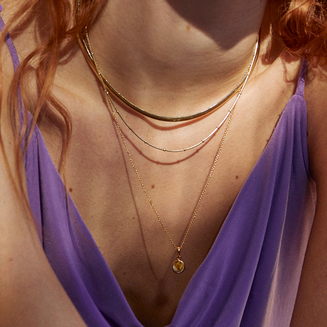 Model wearing a smoky quartz gemstone on a gold chain