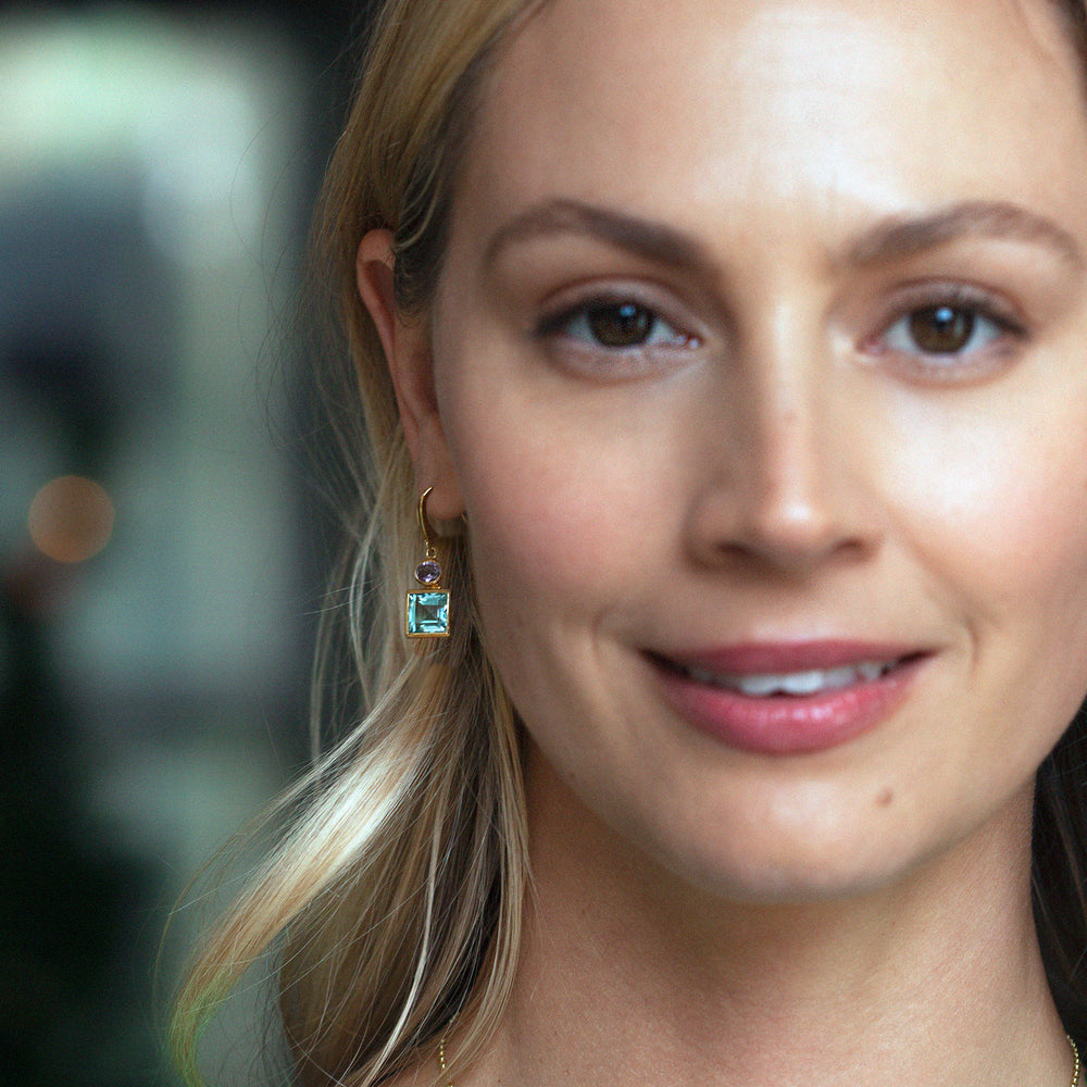 Model wearing 18ct gold vermeil blue topaz and amethyst square drop earrings
