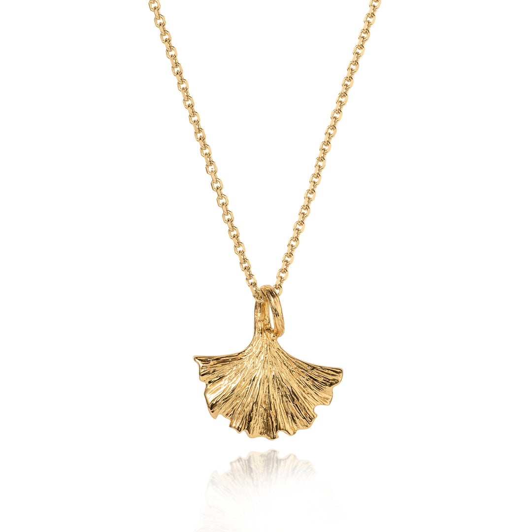 Gold necklace with a ginkgo leaf pendant on a white background