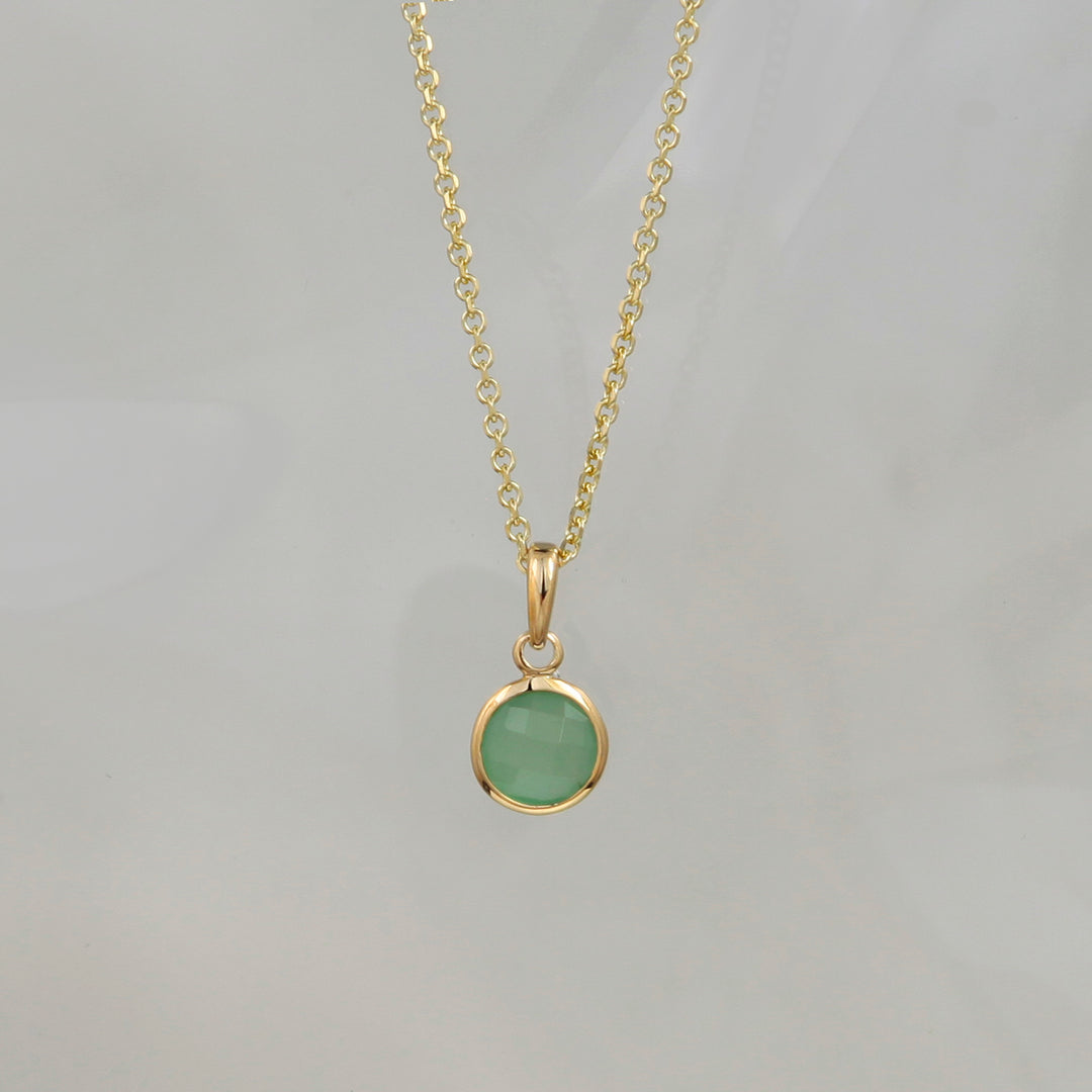 green quartz pendant in gold plated silver against a gray background