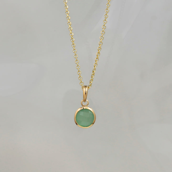 green quartz pendant in gold plated silver against a gray background