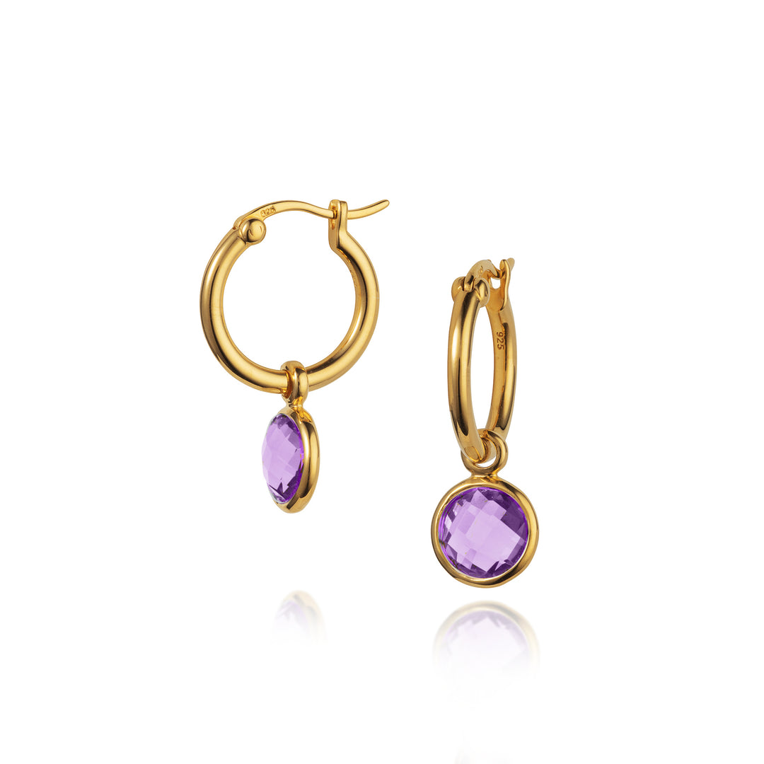 Gold hoop earrings with purple gemstones on a white background