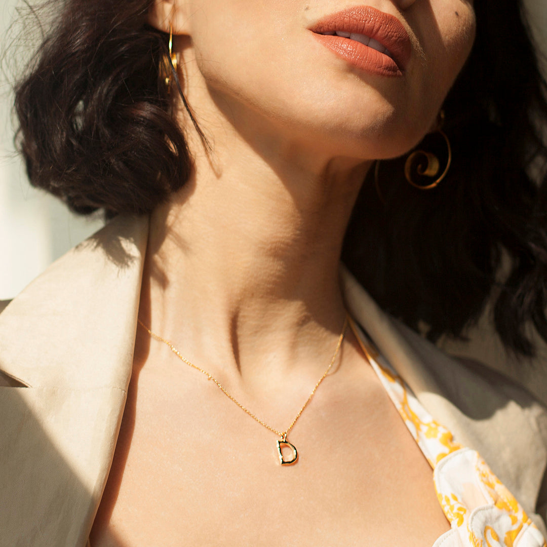 Model wearing a gold initial necklace