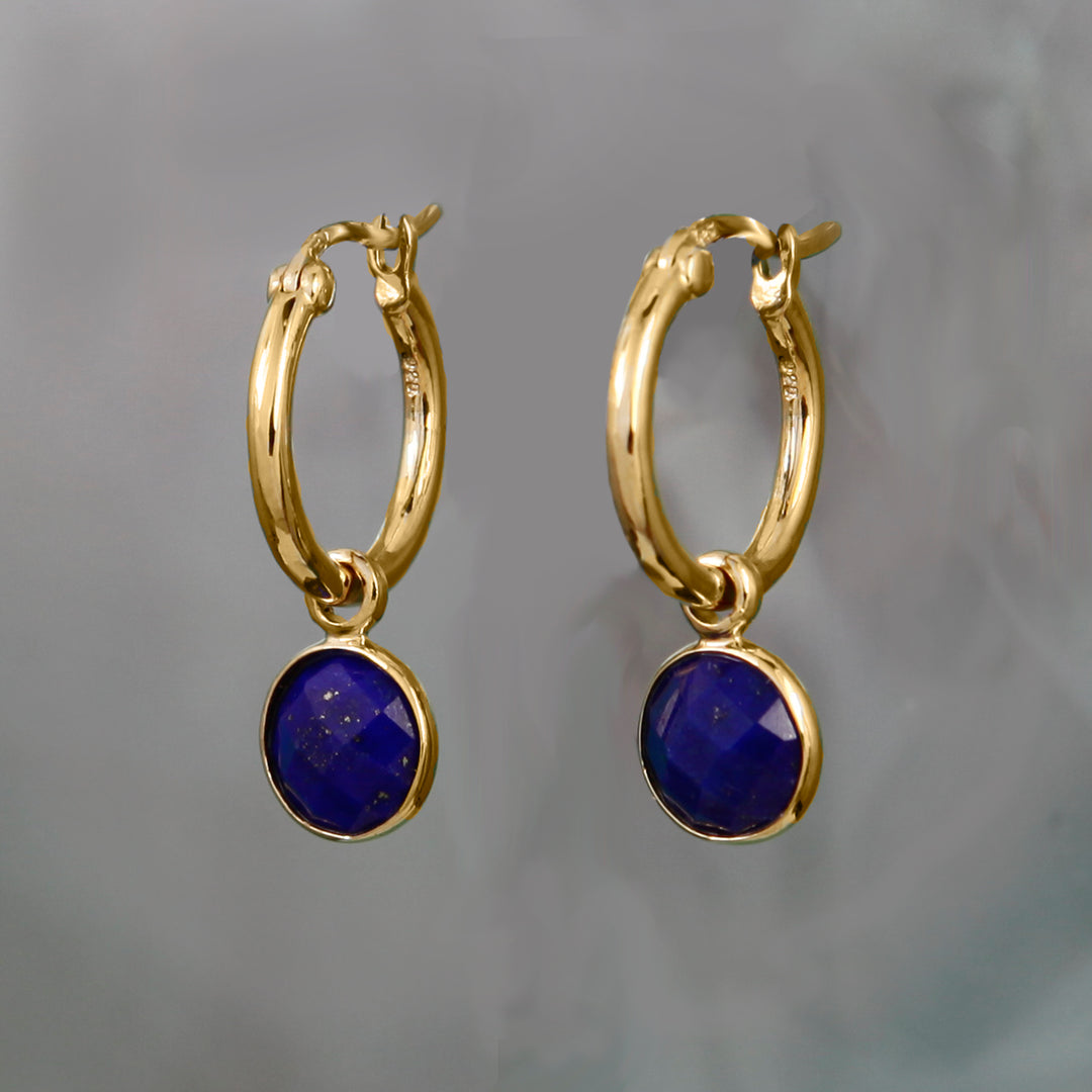 blue lapis earrings in gold on a gray background