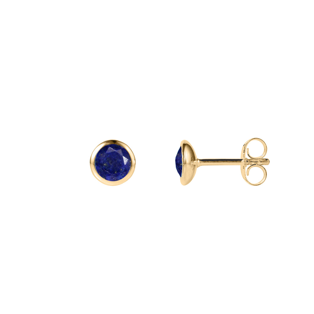 dainty gold stud earrings with dark blue lapis lazuli gemstones on a white background.