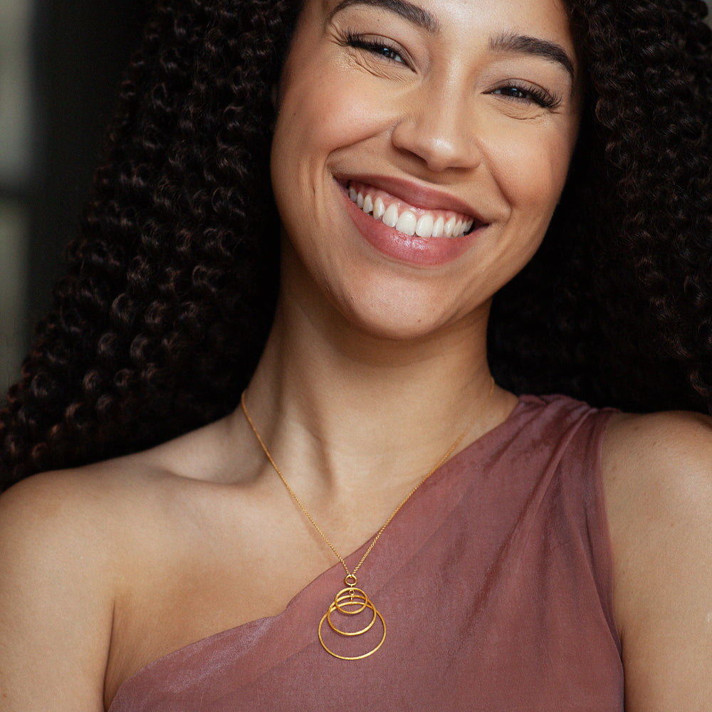 Woman wearing a gold necklace of three overlapping rings