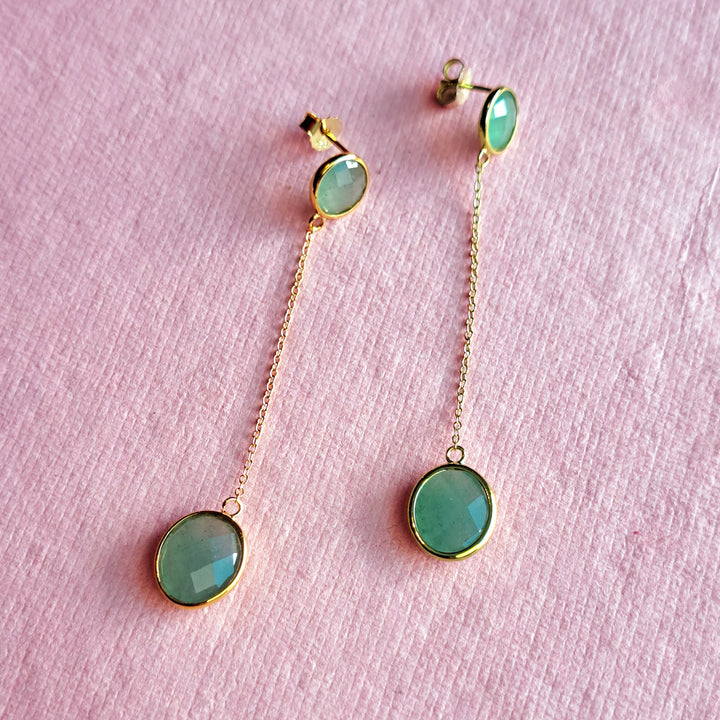 18ct gold vermeil long drop earrings with jade-green aventurine gemstones on a pink background