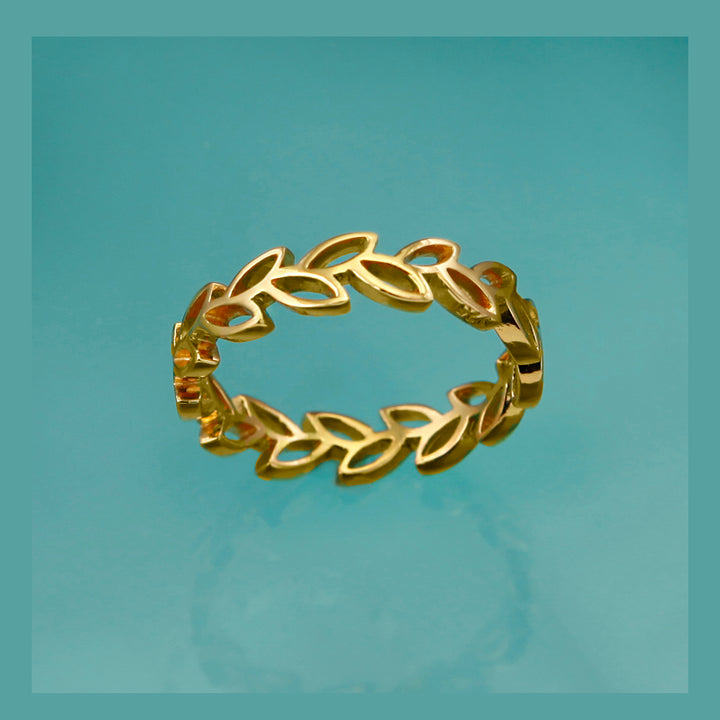 18ct gold vermeil laurel leaf ring on an aqua background