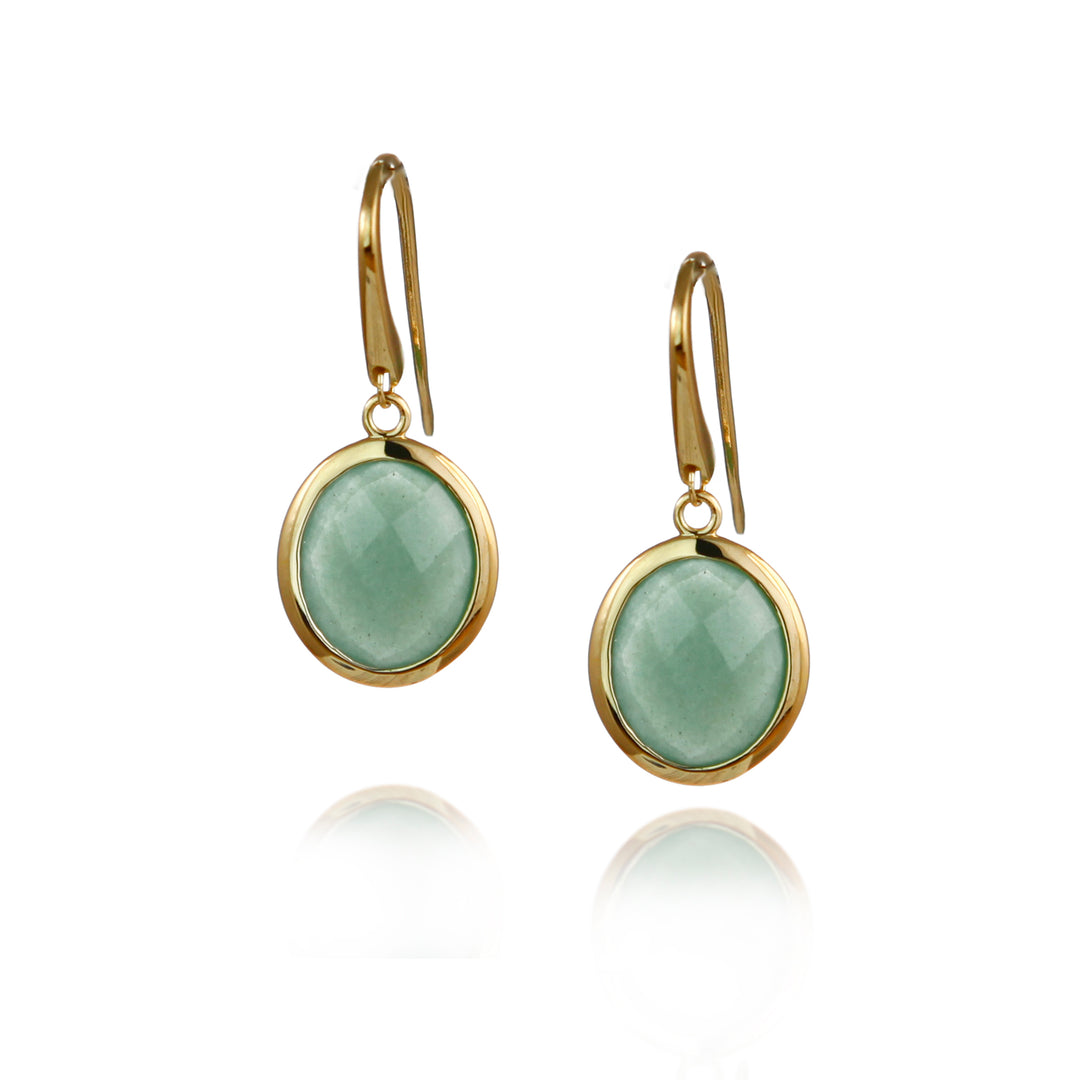 Gold earrings with green gemstones on a white background