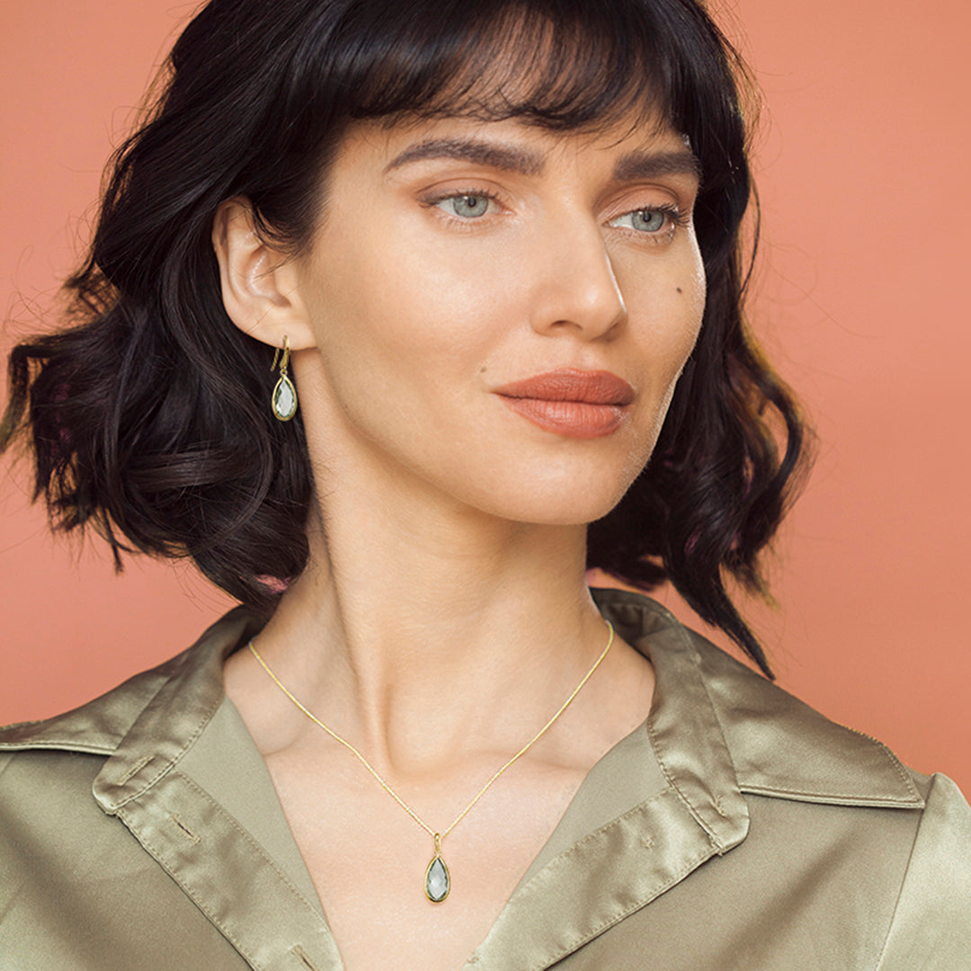 Woman wearing 18ct gold vermeil pear drop earrings and necklace set in green amethyst