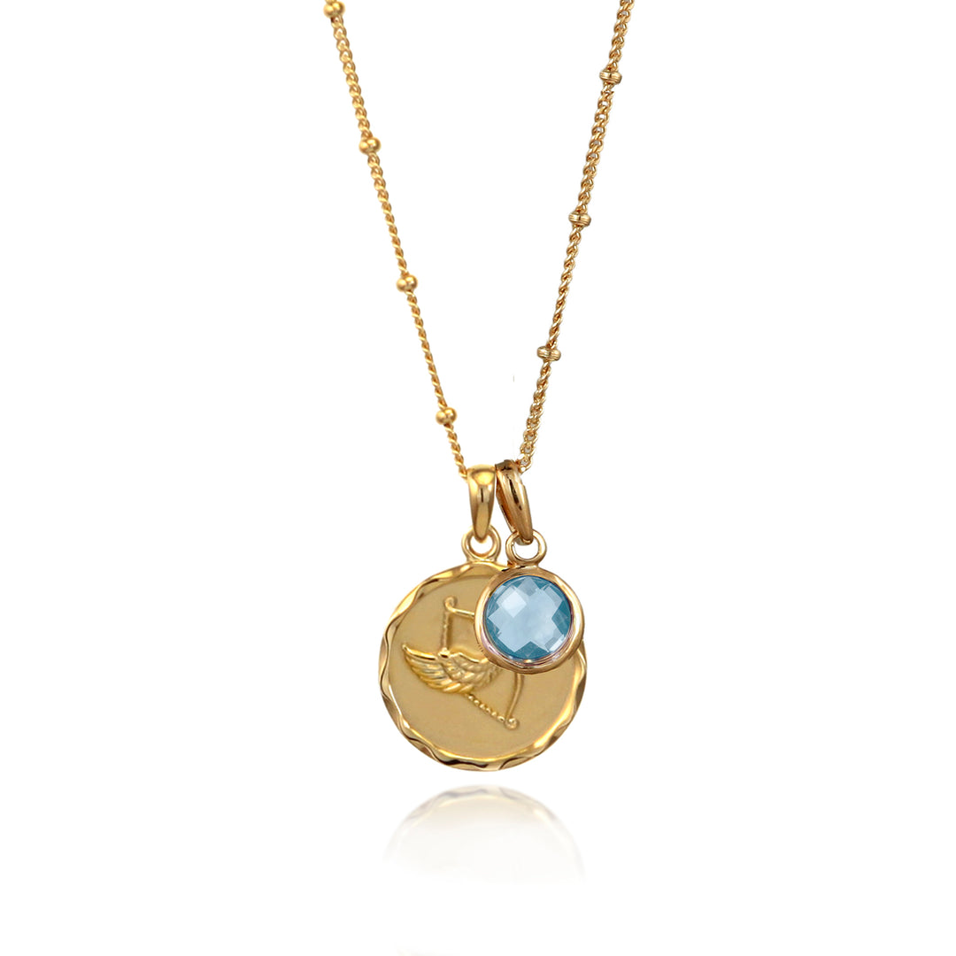 Gold zodiac pendant  with scorpio star sign and blue topaz december birthstone charm on gray background