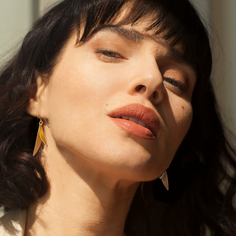 Close-up of model wearing gold drop earrings