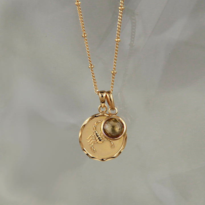 Gold zodiac pendant  with scorpio star sign and smoky quartz November birthstone charm on gray background