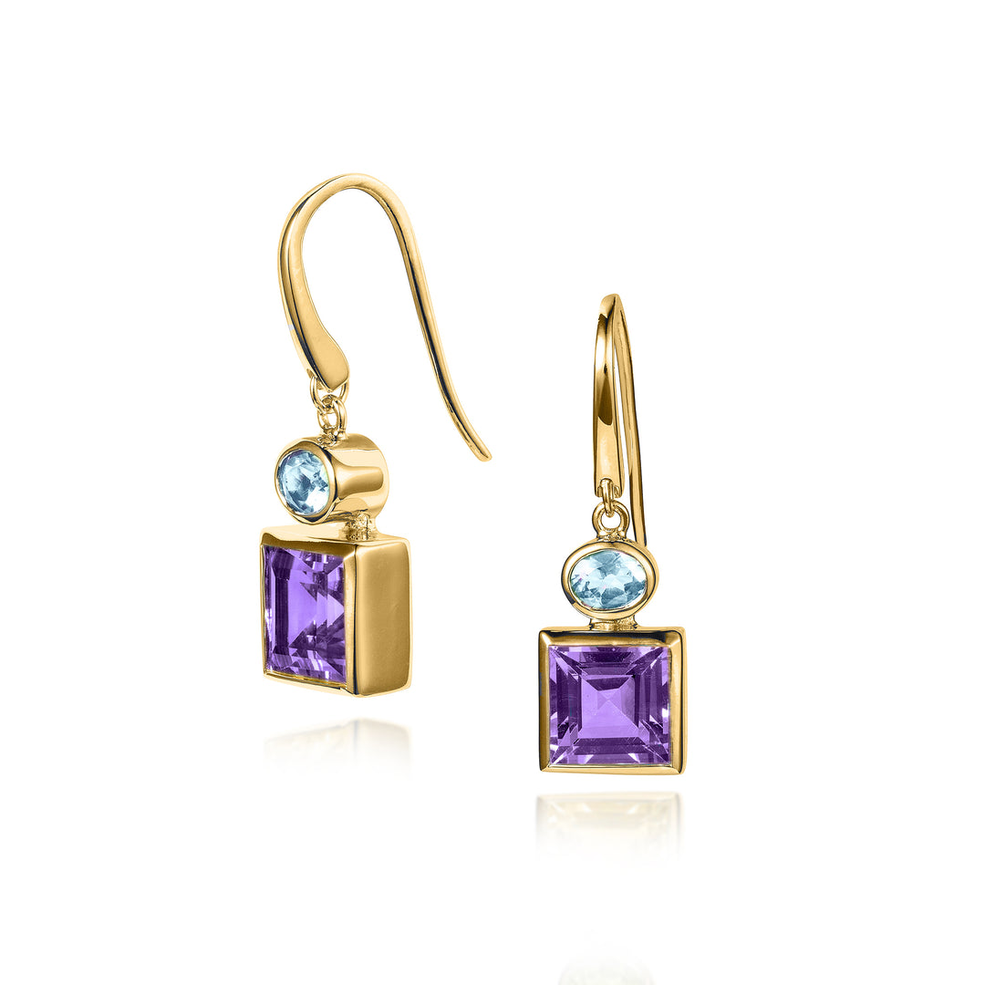 Gold earrings with square purple and oval blue gemstones on a white background
