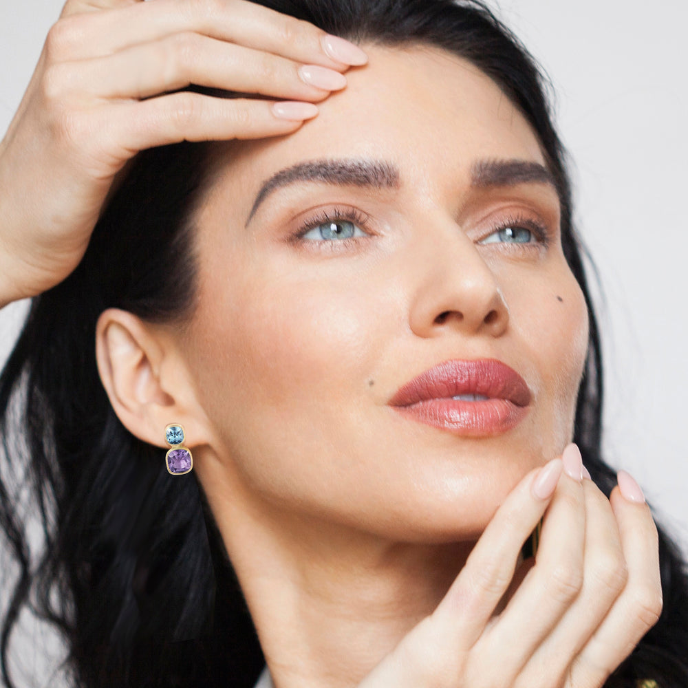 Close-up of a model wearing sterling silver blue topaz and peridot stud earrings