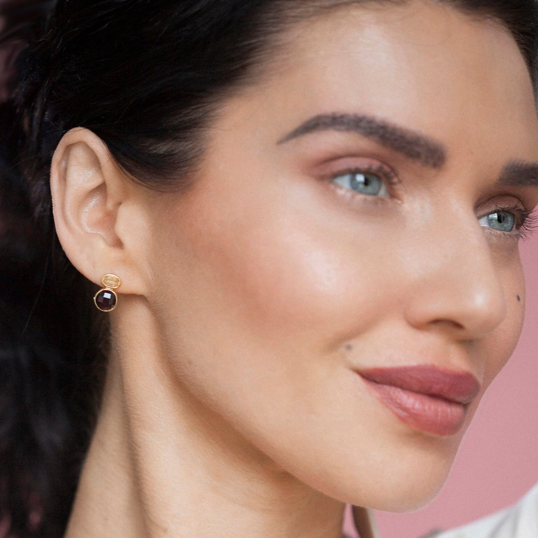Close-up of woman wearing garnet & citrine stud earrings set in 18ct  gold vermeil