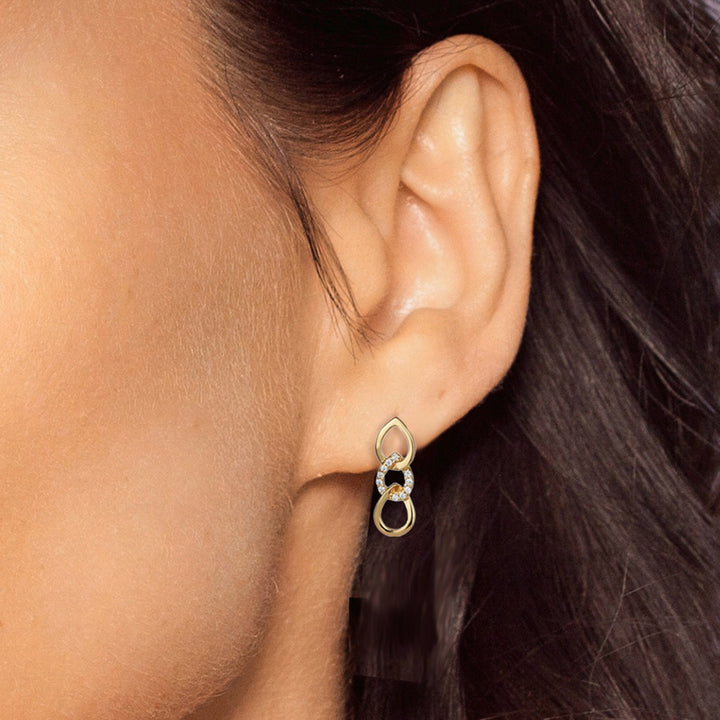 Close-up of gold vermeil cubic zirconia stud earrings on a model