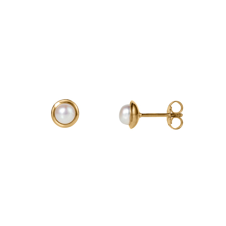 Small round gold pearl stud earrings on a white background