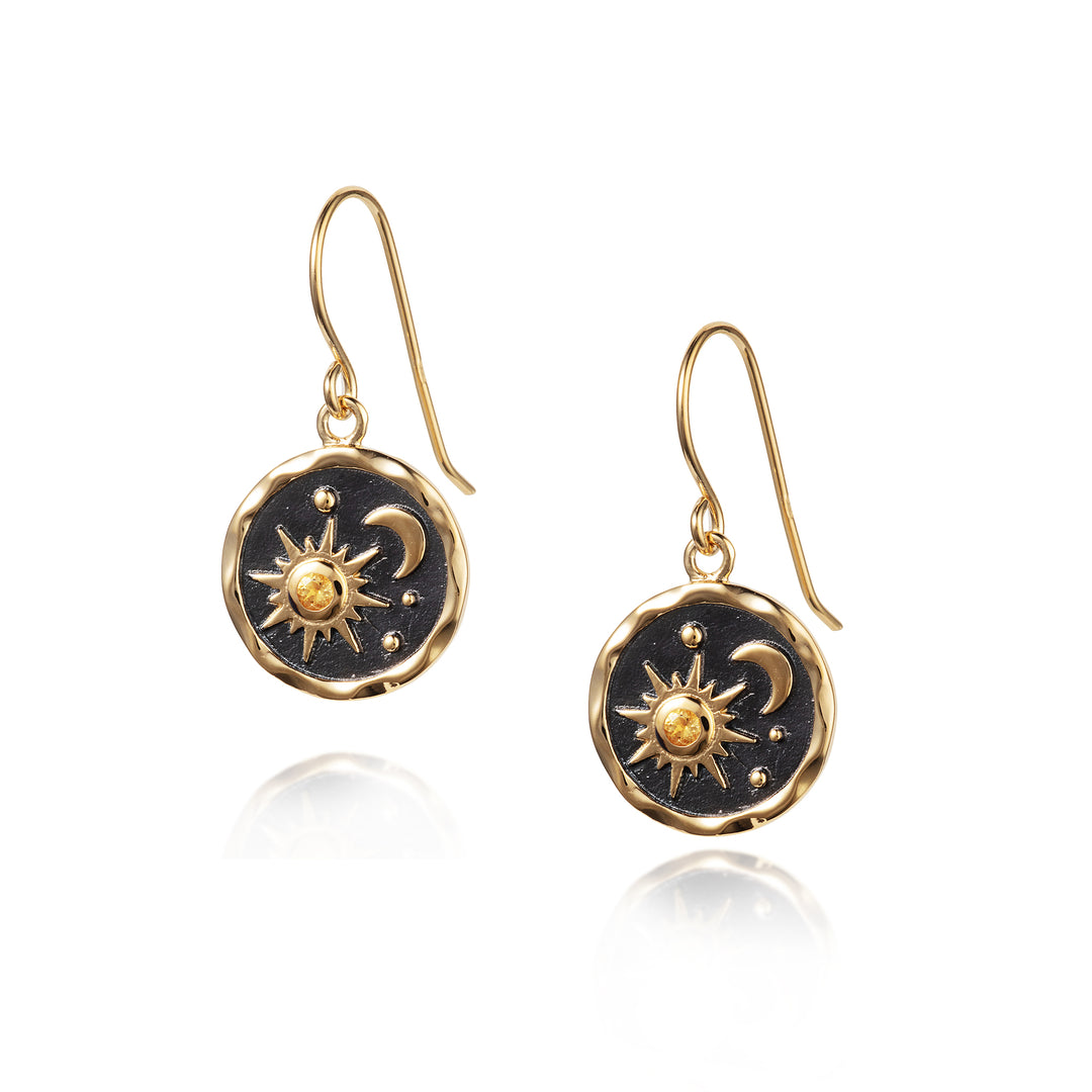 Gold sun and moon themed earrings with black background and a citrine gemstone