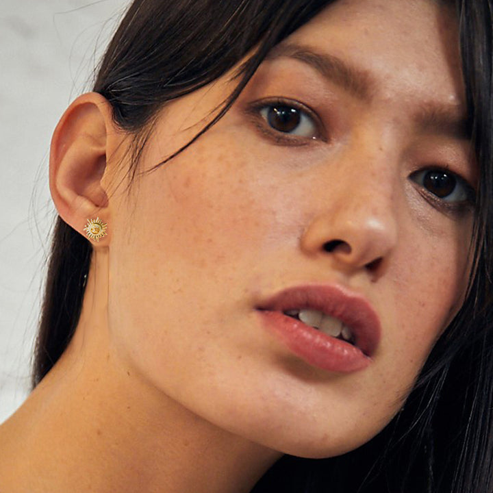 Close-up model wearing gold sun studs with citrine gemstones