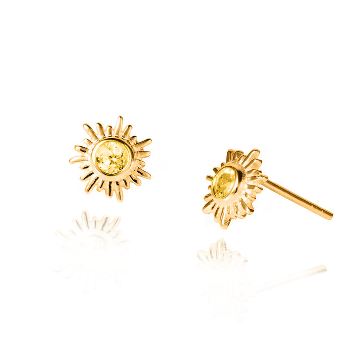 Gold sun post earrings with yellow citrine gemstones on a white background