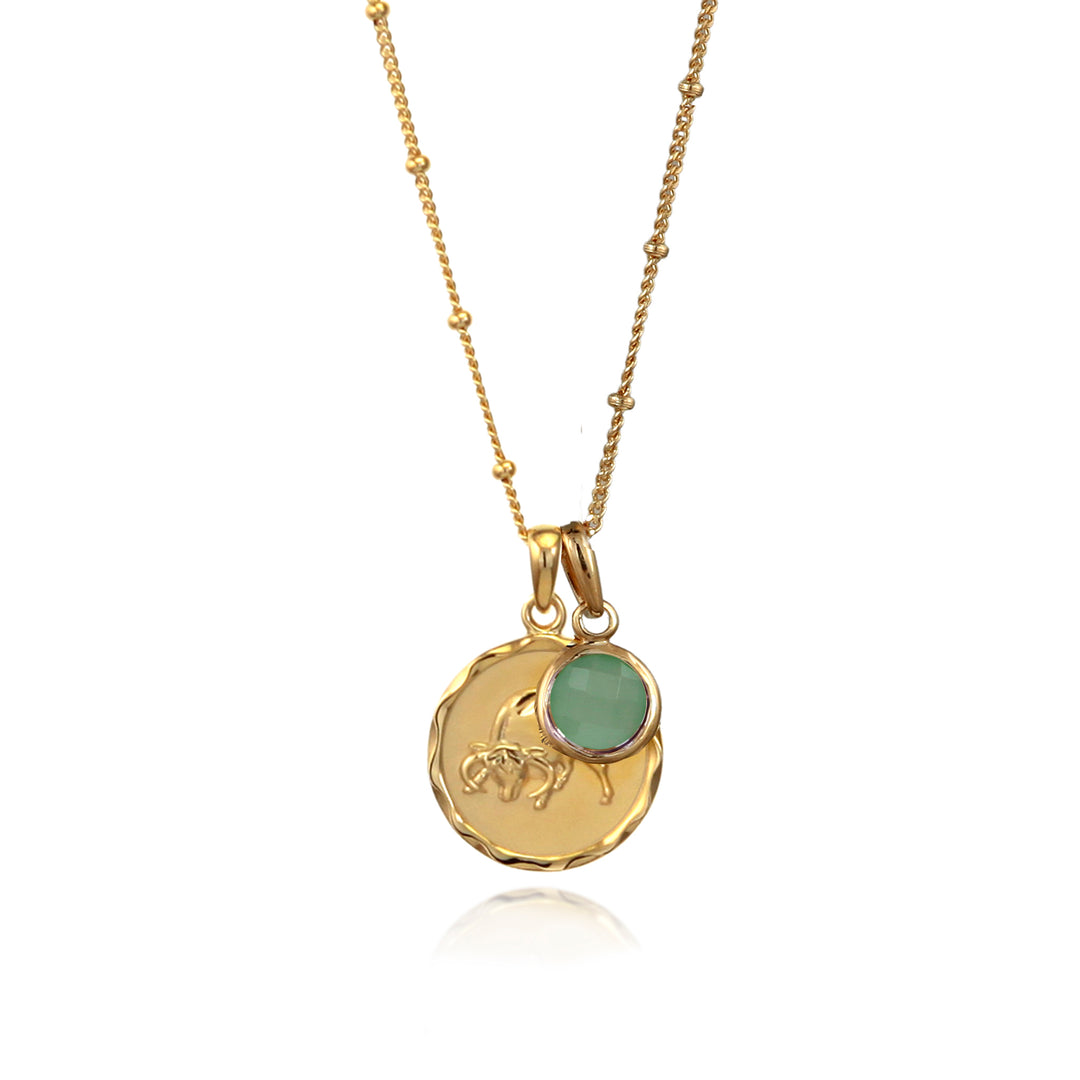 Gold Taurus star sign pendant necklace with a green quartz May birthstone charm on a white background
